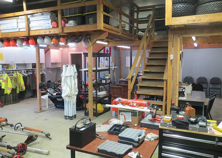 Interior of Acer Landscaping's shop with a large variety of tools and safety gear