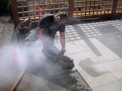 Steve Woodhouse, owner of Acer Landscaping, cutting patio slabs using a concrete cut-off saw