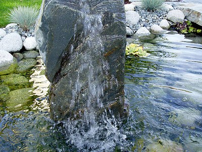 Large basalt bubbler column in a water feature in a residential lot in Nanaimo BC