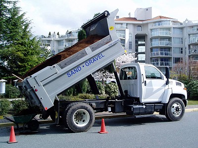 Dump truck near a condo development in Nanaimo, dumping bark mulch for landscape maintenance