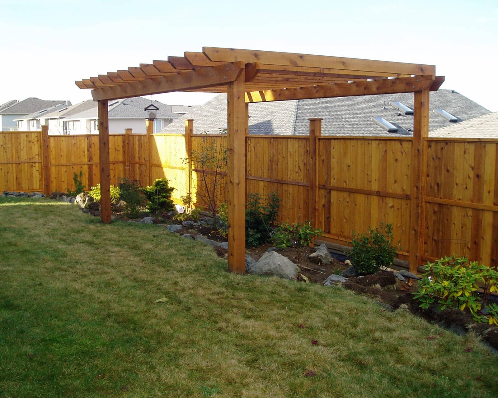 Residential backyard with a custom cedar fence and free-standing pergola