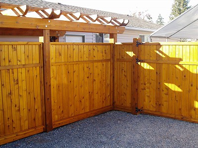Custom cedar fence with a matching pergola in a residential yard